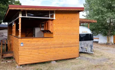 a small wooden house with a truck parked next to it at Luxury Vintage Airstream RV/Caravan Retro Charm Meets Comfort in Kiten