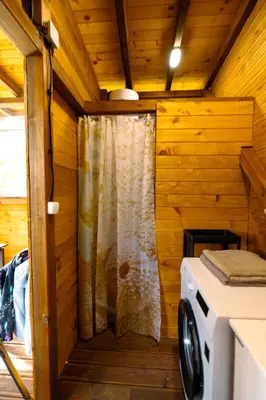 a shower in a cabin with a washing machine at Luxury Vintage Airstream RV/Caravan Retro Charm Meets Comfort in Kiten
