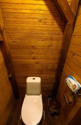 a toilet in a small room with wooden walls at Luxury Vintage Airstream RV/Caravan Retro Charm Meets Comfort in Kiten