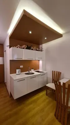 a kitchen with white cabinets and a sink and a table at Sweet Home 2 Apartment in Sunny Beach
