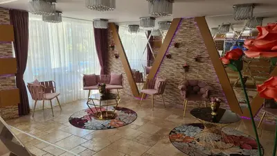 a salon with chairs and tables and a brick wall at Sweet Home 2 Apartment in Sunny Beach