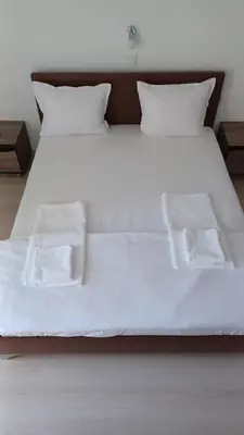 a white bed with white sheets and pillows at ARIA in Primorsko