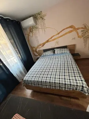 a bedroom with a bed with a branch on the wall at Desis Seaside Hideaway in Pomorie