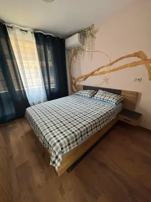 a bedroom with a bed with a checkered blanket on it at Desis Seaside Hideaway in Pomorie