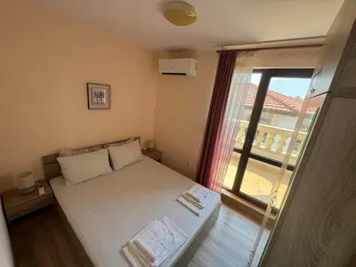 a small bedroom with a bed and a window at Luxury Apartments Ekaterina in Chernomorets