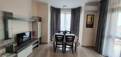 a living room with a table with chairs and a television at Luxury Apartments Ekaterina in Chernomorets