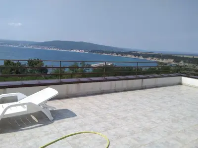 a white bench sitting on a balcony overlooking the water at Апартаменты за гости Гаван in Byala
