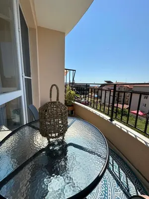 a glass table with a basket on top of a balcony at Ив-Бо in Ravda