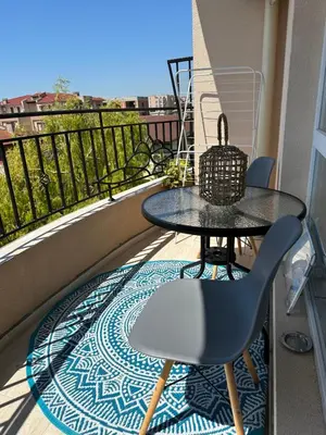 a table and a chair on a balcony with a view at Ив-Бо in Ravda