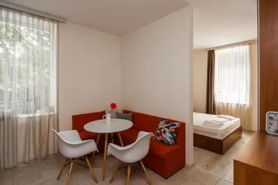 a room with a table and chairs and a bed at Central location and FREE parking in Varna City