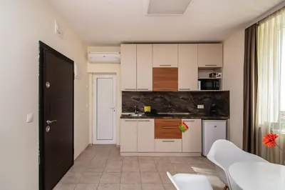 a small kitchen with white cabinets and a table at Central location and FREE parking in Varna City