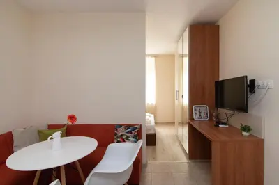 a living room with a red couch and a white table at Central location and FREE parking in Varna City