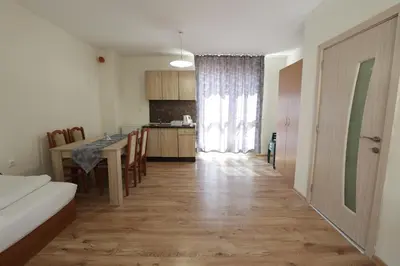 a living room with a table and a kitchen at апартамент Зевс in Pomorie
