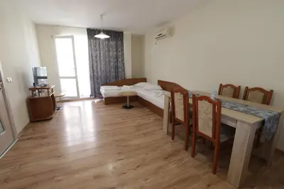 a living room with a table and a couch at апартамент Зевс in Pomorie