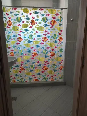 a shower curtain with umbrellas in a bathroom at апартамент Зевс in Pomorie