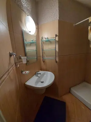 a bathroom with a white sink and a shower at Kapriz Apartment in Kiten