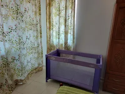 a purple crib in a room with curtains at Kapriz Apartment in Kiten
