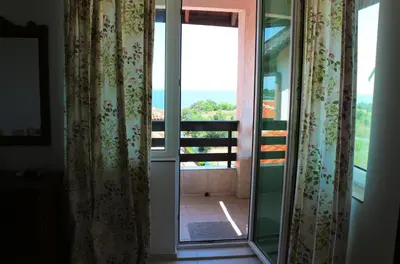an open glass door with a view of a balcony at Kapriz Apartment in Kiten