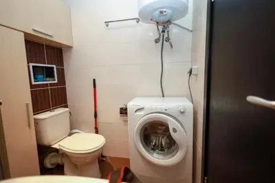 a bathroom with a toilet and a washing machine at Santa Cruz apartment in Burgas City
