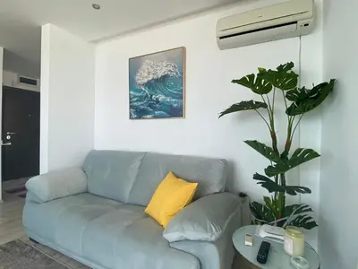 a blue couch in a living room with a yellow pillow at PARADISO 'В' 207 Two Bedroom Apartment in Nesebar
