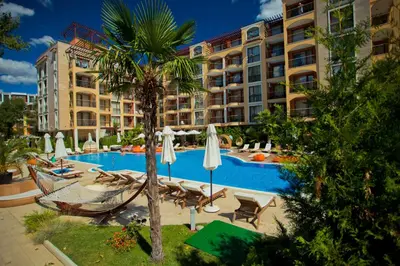 a resort swimming pool with a hammock and a palm tree at Harmony Suites Jungle - Family Friendly Complex in Sunny Beach