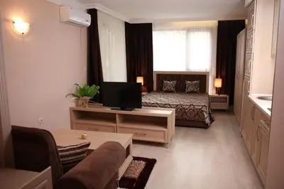 a hotel room with a bed and a television at Harmony Suites Jungle - Family Friendly Complex in Sunny Beach