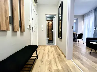 a living room with a couch and a hallway at Sea Garden Apartment in Burgas City