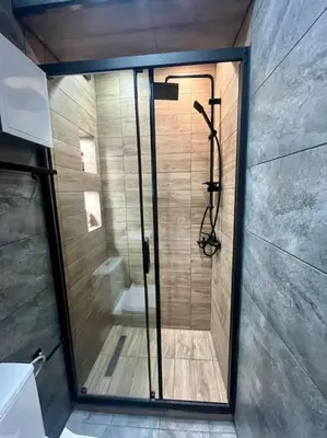 a shower with a glass door in a bathroom at Sea Garden Apartment in Burgas City
