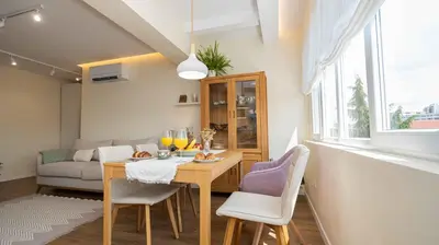 a living room with a table and chairs and a couch at Central DELUXE Apartment in Burgas City