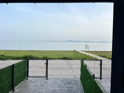 a gate on a beach with the ocean in the background at Aliara Dilara Beach Apartments in Pomorie