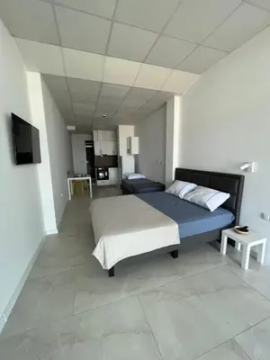 a bedroom with a bed and a tv in it at Aliara Dilara Beach Apartments in Pomorie