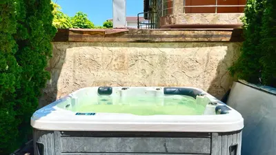 a jacuzzi tub in front of a building at Bratanov Cascadas Ravda in Ravda
