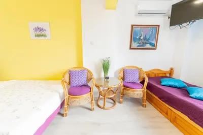 a room with two beds and a table and chairs at Casa Del Mare in Chernomorets