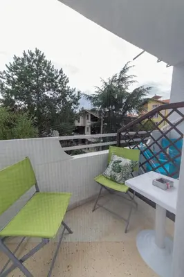 two green chairs and a table on a balcony at Casa Del Mare in Chernomorets