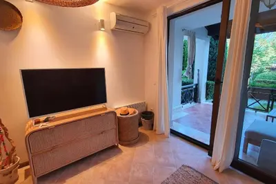 a living room with a flat screen tv on a wall at Oasis Resort Apartment, Луксозен Апартамент в комплекс ОАЗИС in Lozenets