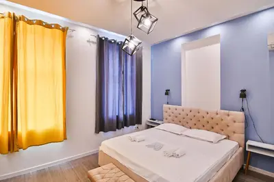 a bedroom with a bed and a yellow curtain at Central Flats with parking in Varna City