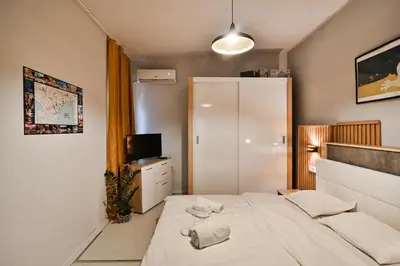 a small bedroom with a bed and a refrigerator at Central Flats with parking in Varna City