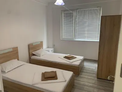 two beds in a small room with a window at Апартамент Енигма/Apart Enigma in Sveti Vlas