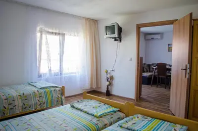 a hotel room with two beds and a television at Morski Rai Apartments in Byala