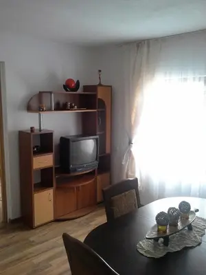 a living room with a table and a tv at Morski Rai Apartments in Byala