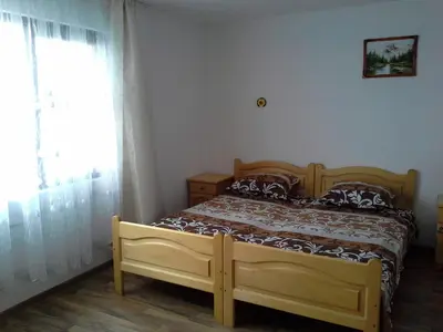 a bedroom with a wooden bed and a window at Morski Rai Apartments in Byala