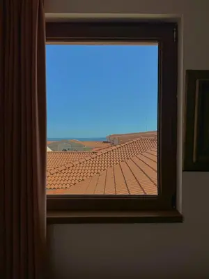 a window with a view of a tile roof at Apartment Royal Bay Sveti Vlas in Sveti Vlas