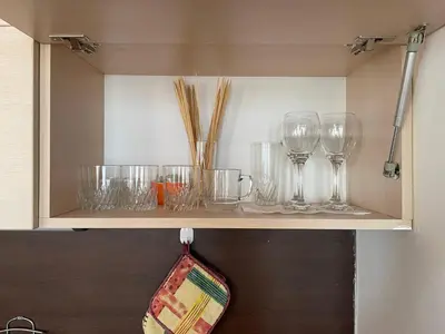 a shelf with wine glasses and chopsticks on it at Apartment Royal Bay Sveti Vlas in Sveti Vlas