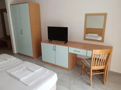 a bedroom with a desk with a television and a bed at Sol e Mar in Sunny Beach