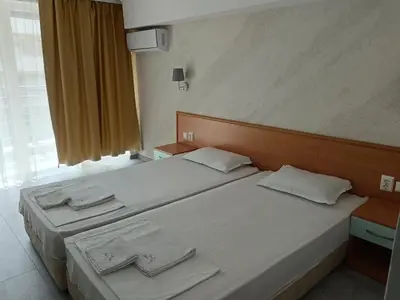 a bedroom with two beds with white sheets and a window at Sol e Mar in Sunny Beach