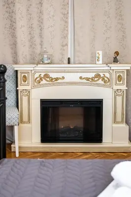 a fireplace in a living room with a white mantle at Aristocratic 2bdrm Central Apartment in Varna City