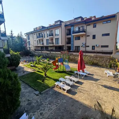 a group of chairs and umbrellas next to a building at Panorama Bay 2 - Apartments by the beach in Sveti Vlas