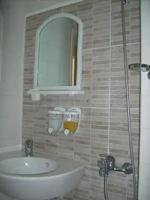 a bathroom with a sink and a mirror at Hotel Pasians in Pomorie
