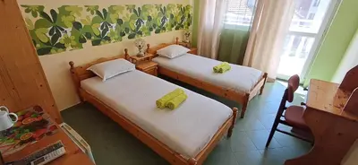 a room with two beds with yellow towels on them at Hotel Pasians in Pomorie