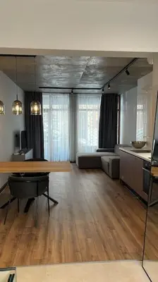 a living room with a table and a couch at Amber Home - brand NEW luxury 1 bedroom apartment located in the very city center in Varna City